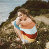 Pull bohème en tricot arc-en-ciel Shelby photo de coté assus sur falaise naturelle